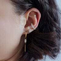 Orecchio con cristallo Ice Flower dorato, indossato con altri piercing dorati