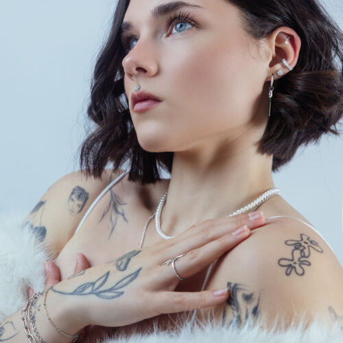 Donna con cristallo Ice Flower nell'orecchio, colore argento, su sfondo neutro