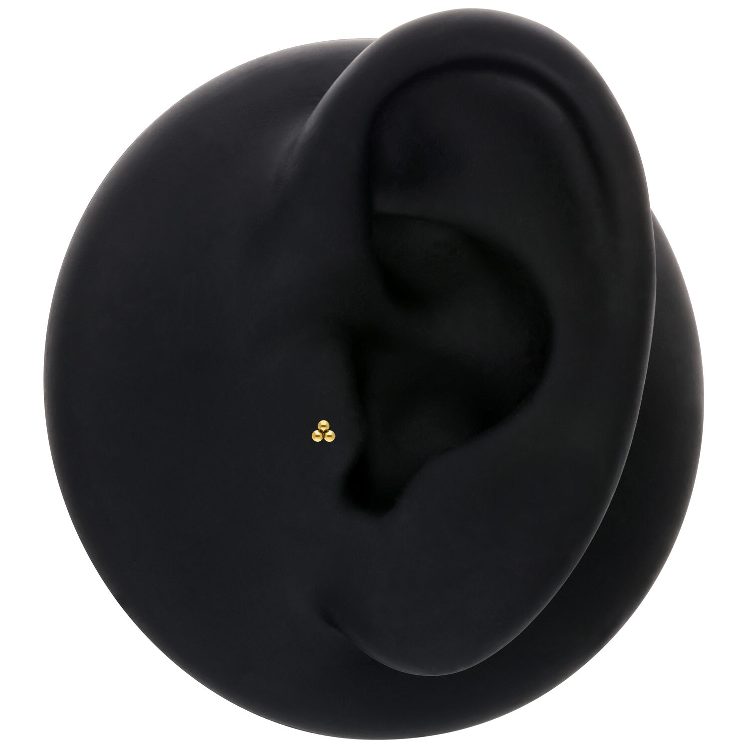 Modello di orecchio nero con inserto Trinity Push Fit dorato su sfondo neutro