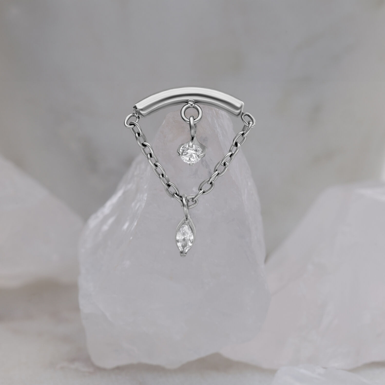 Ornamento elica argento con due cristalli chiari su sfondo marmorizzato