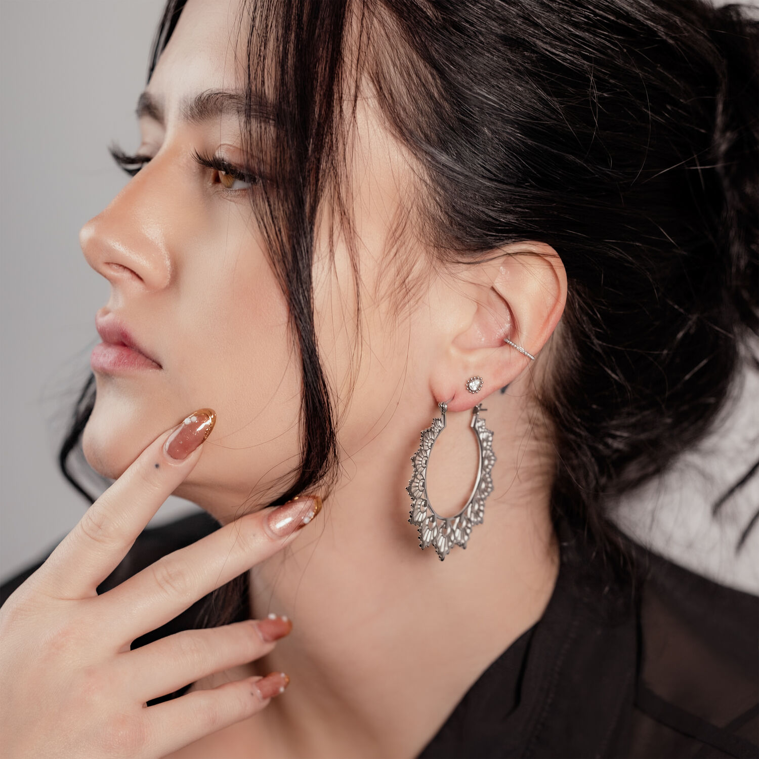 Donna con capelli neri indossa orecchini Sunflower Hoops in argento