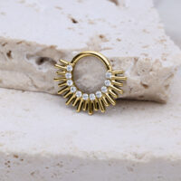 Septum Clicker dorato con design a raggi e cristalli su pietra chiara