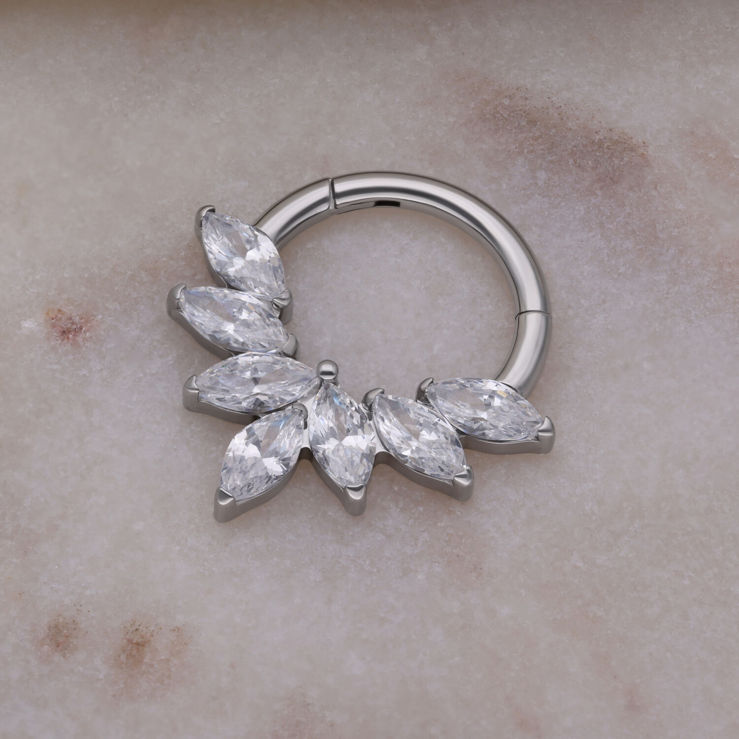 Septum Clicker in argento con cristalli Marquise su sfondo di marmo