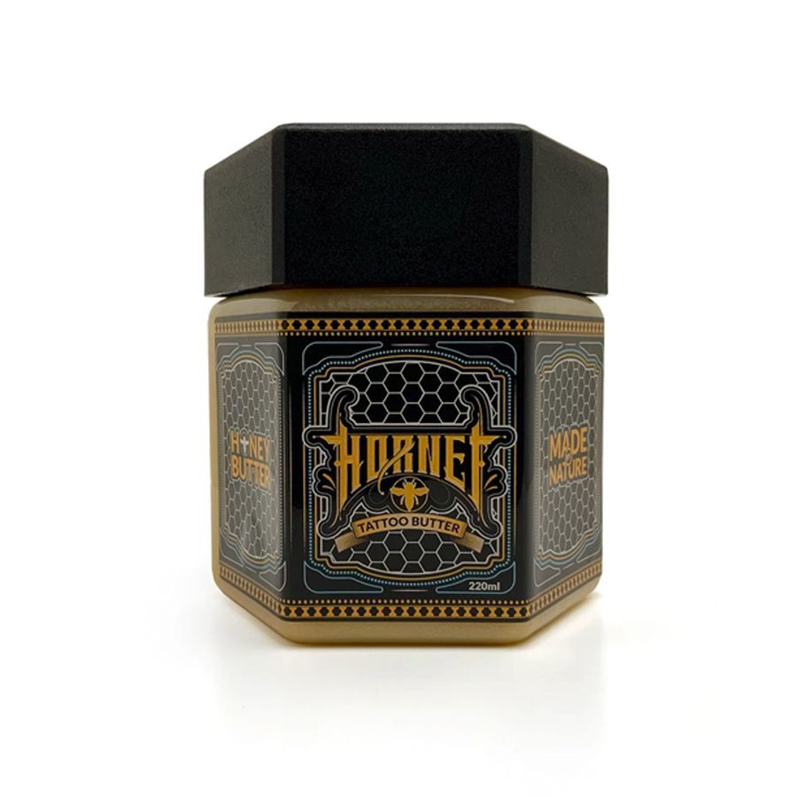 Vasetto nero e dorato di Hornet Honey Butter su sfondo bianco