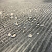 Primo piano di un rotolo di copertura nero impermeabile con gocce d'acqua