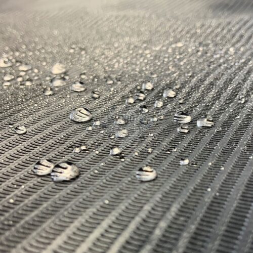 Primo piano di un rotolo di copertura nero impermeabile con gocce d'acqua