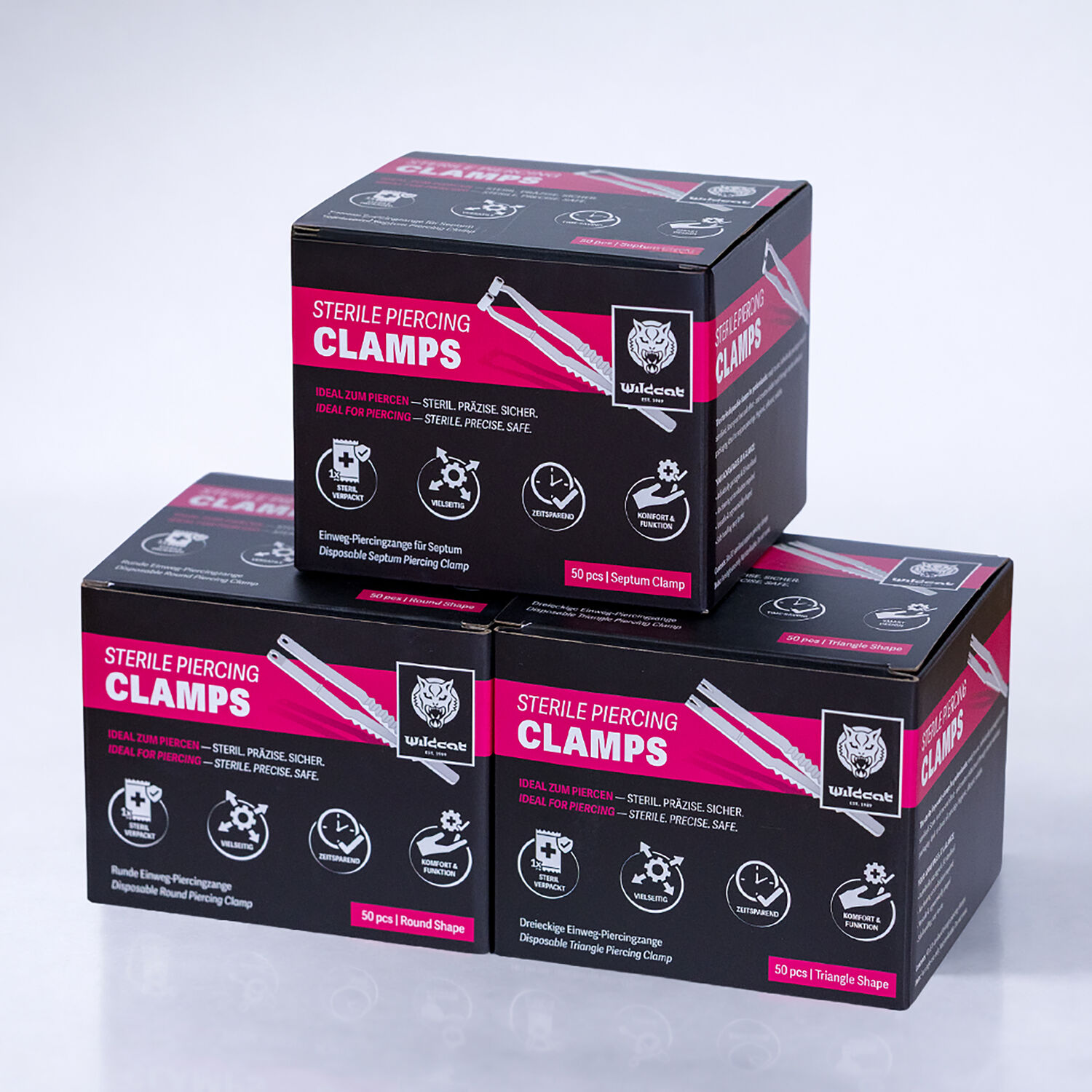 Tre scatole nere con la scritta 'Sterile Piercing Clamps' su sfondo bianco