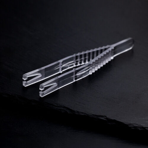 Chiara pinza sterile triangolare per piercing su sfondo nero, confezionata singolarmente