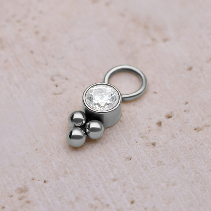 Ciondolo piercing argento con cristallo e sfere su sfondo chiaro