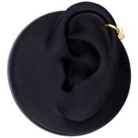 Pendente rotondo in cristallo dorato per piercing all'orecchio Pendente rotondo in cristallo dorato su modello di orecchio nero su sfondo bianco