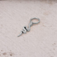 Pendente a serpente in acciaio chirurgico argentato su sfondo chiaro