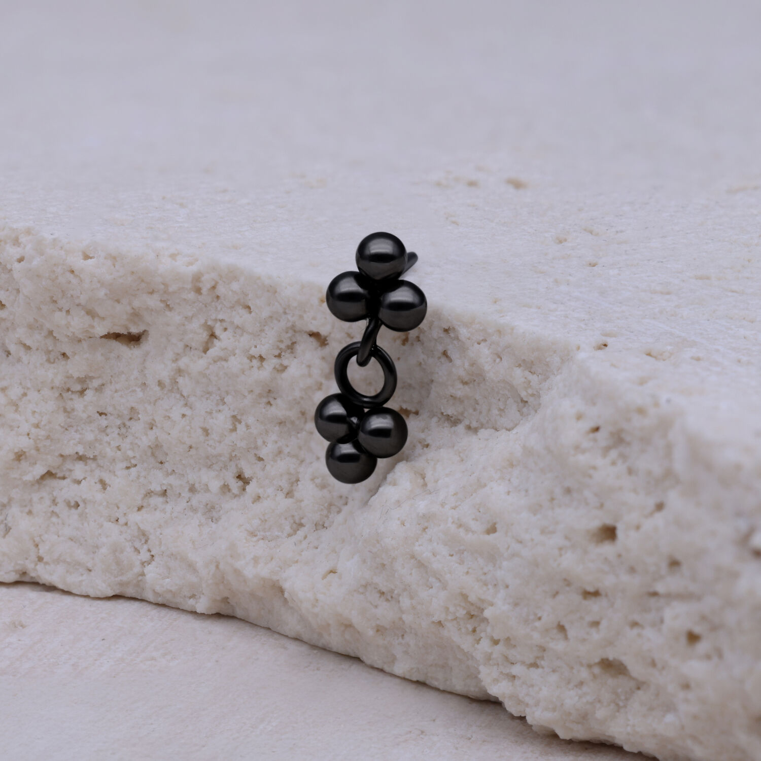 Pendente in titanio nero con sfere su sfondo chiaro