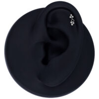 Argento Push Fit Trinity pendente su modello di orecchio nero su sfondo grigio