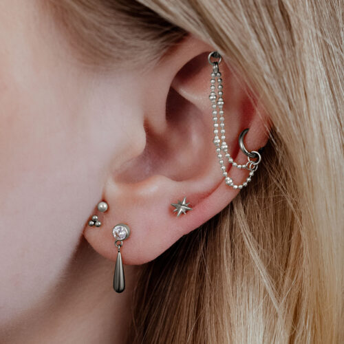 Inserto Push Fit a forma di stella in argento in un piercing all'orecchio, primo piano