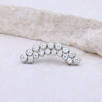 Accessorio in argento con pietre cristalline, a forma di semicerchio su sfondo chiaro