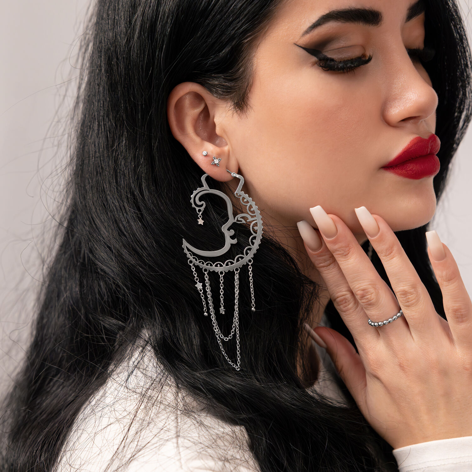 Donna con Sun Moon Hoops in argento, profilo laterale, sfondo liscio