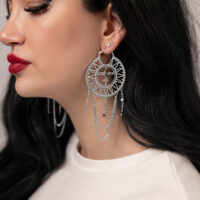 Orecchini d'argento con design sole-luna su donna con capelli scuri