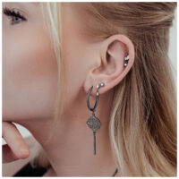 Orecchini neri Clover Hoops in acciaio chirurgico all'orecchio di una donna