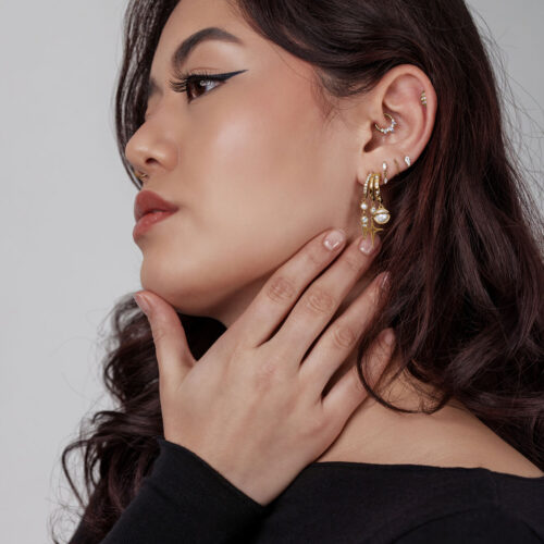 Donna con orecchini Pearl Starlight dorati, profilo laterale