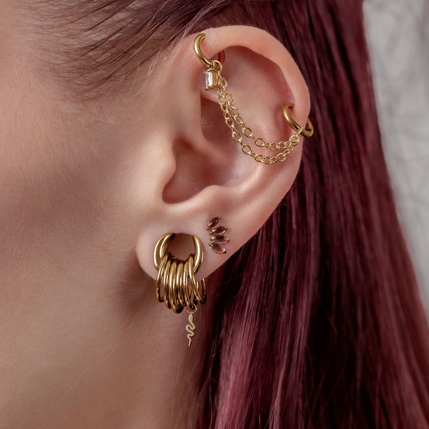 Doppia catena piercing dorata di 40mm indossata su un orecchio