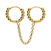 Huggie piercing dorati con sfere e catena su sfondo bianco