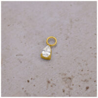 Pendente a goccia di cristallo dorato per piercing Pendente per piercing dorato con goccia di cristallo su sfondo chiaro