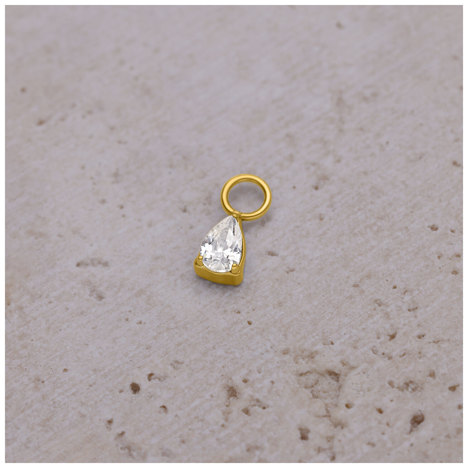 Pendente a goccia di cristallo dorato per piercing Pendente per piercing dorato con goccia di cristallo su sfondo chiaro