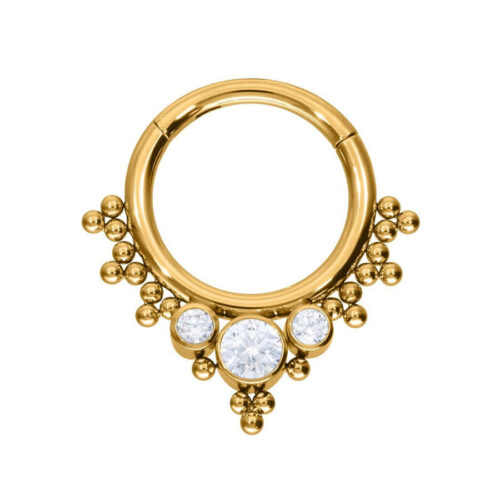 Anello piercing dorato con tre cristalli chiari su sfondo bianco