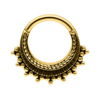 Anello piercing dorato con sfere decorative su sfondo bianco