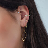 Inserto ovale in cristallo push fit dorato all'orecchio con altri piercing dorati