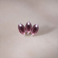 Lotus in argento con tre ametiste su sfondo neutro
