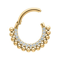 Piercing in titanio dorato con cristalli chiari su sfondo bianco
