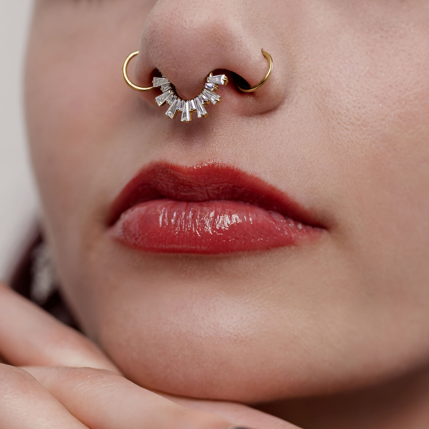 Primo piano di un clicker septum dorato con cristalli su un naso