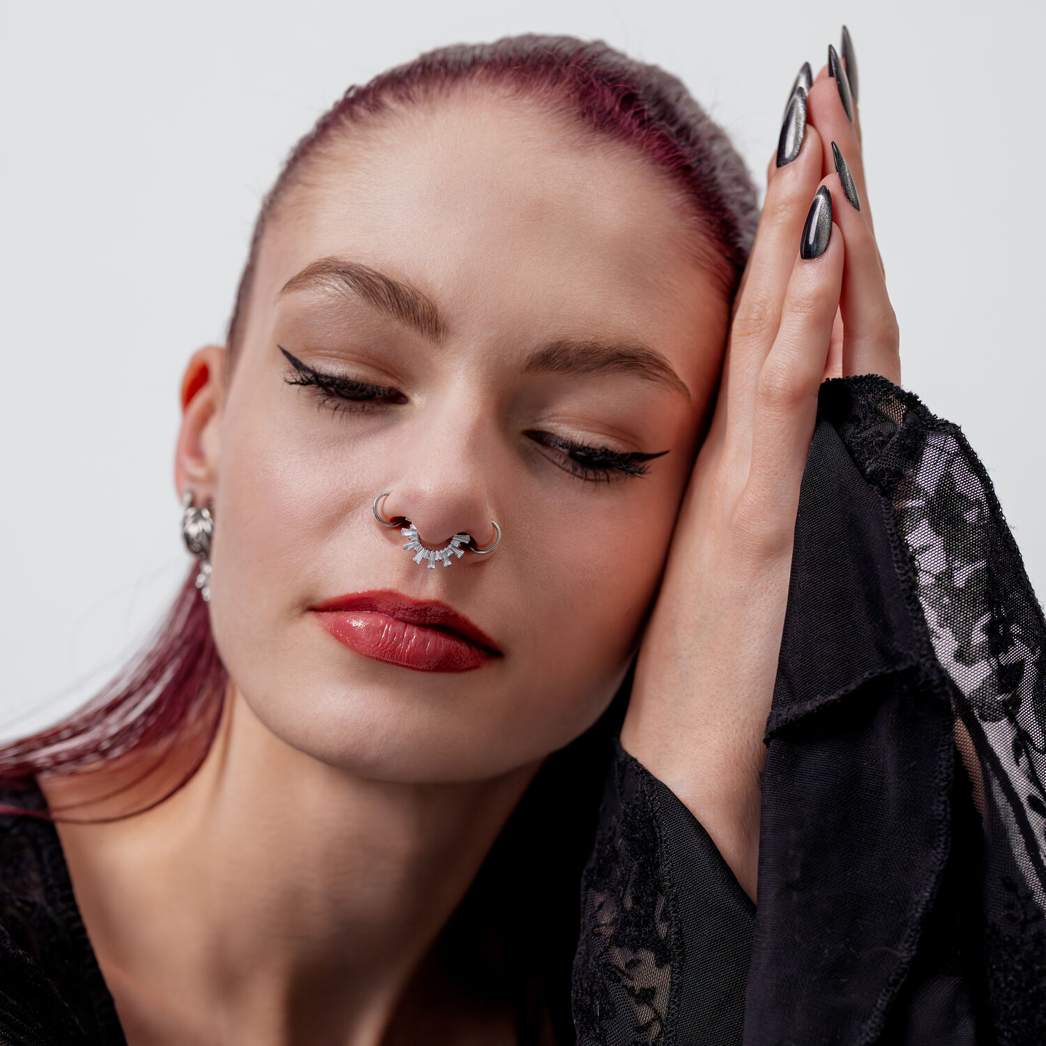 Donna con occhi chiusi, indossa un clicker per setto in cristallo argentato, abbigliamento nero