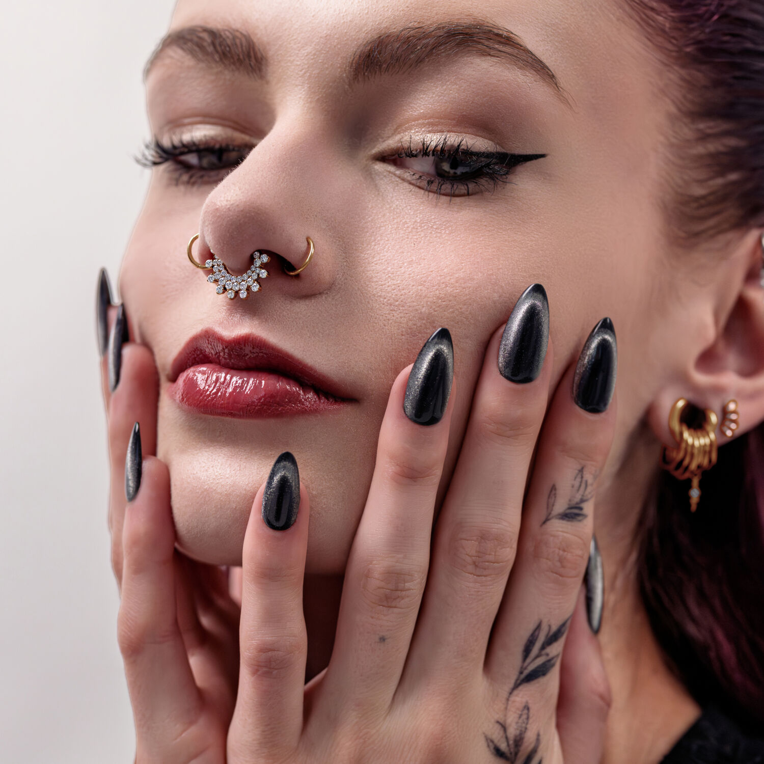 Donna con piercing al setto dorato e cristalli, primo piano