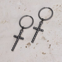 Due cerchi neri con ciondoli a croce di sfere su pietra chiara