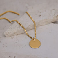 Collana d'oro con ciondolo rotondo su pietra chiara