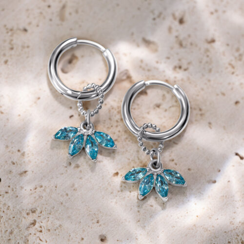 Due orecchini a cerchio in argento con pendenti di cristallo turchese su pietra chiara