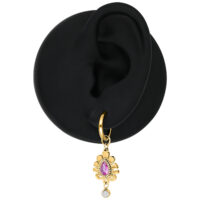Orecchino d'oro con cristallo rosa Orecchino d'oro con cristallo rosa su un modello di orecchio nero