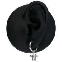 Orecchino d'argento con ciondolo a tartaruga su un modello di orecchio nero