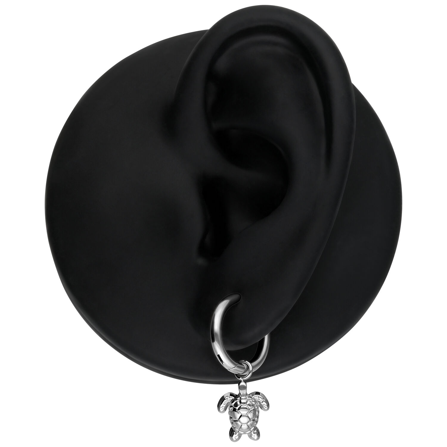 Orecchino d'argento con ciondolo a tartaruga su un modello di orecchio nero