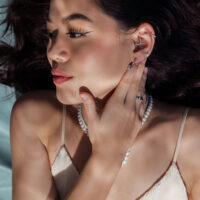 Donna con orecchini d'argento e collana di perle, di lato alla luce