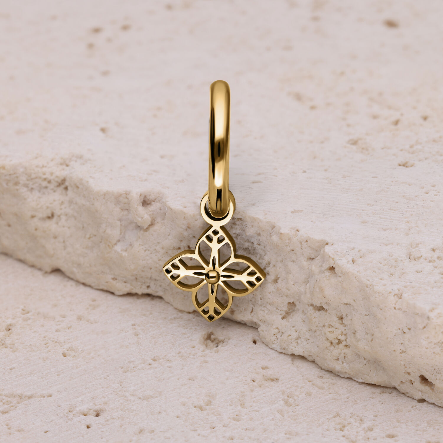 Orecchino dorato con ornamento floreale Orecchino dorato con ornamento floreale su pietra chiara