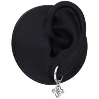 Orecchino d'argento con piccolo ciondolo a fiore, presentato su un modello di orecchio nero