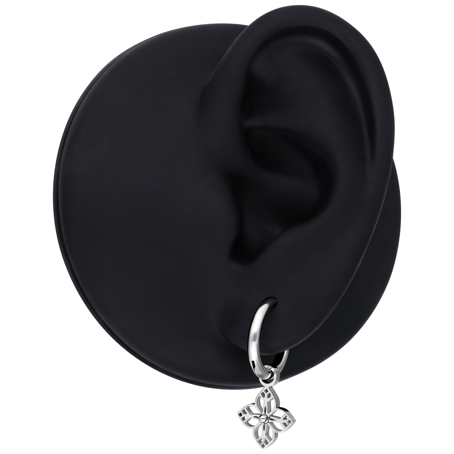 Orecchino d'argento con piccolo ciondolo a fiore, presentato su un modello di orecchio nero