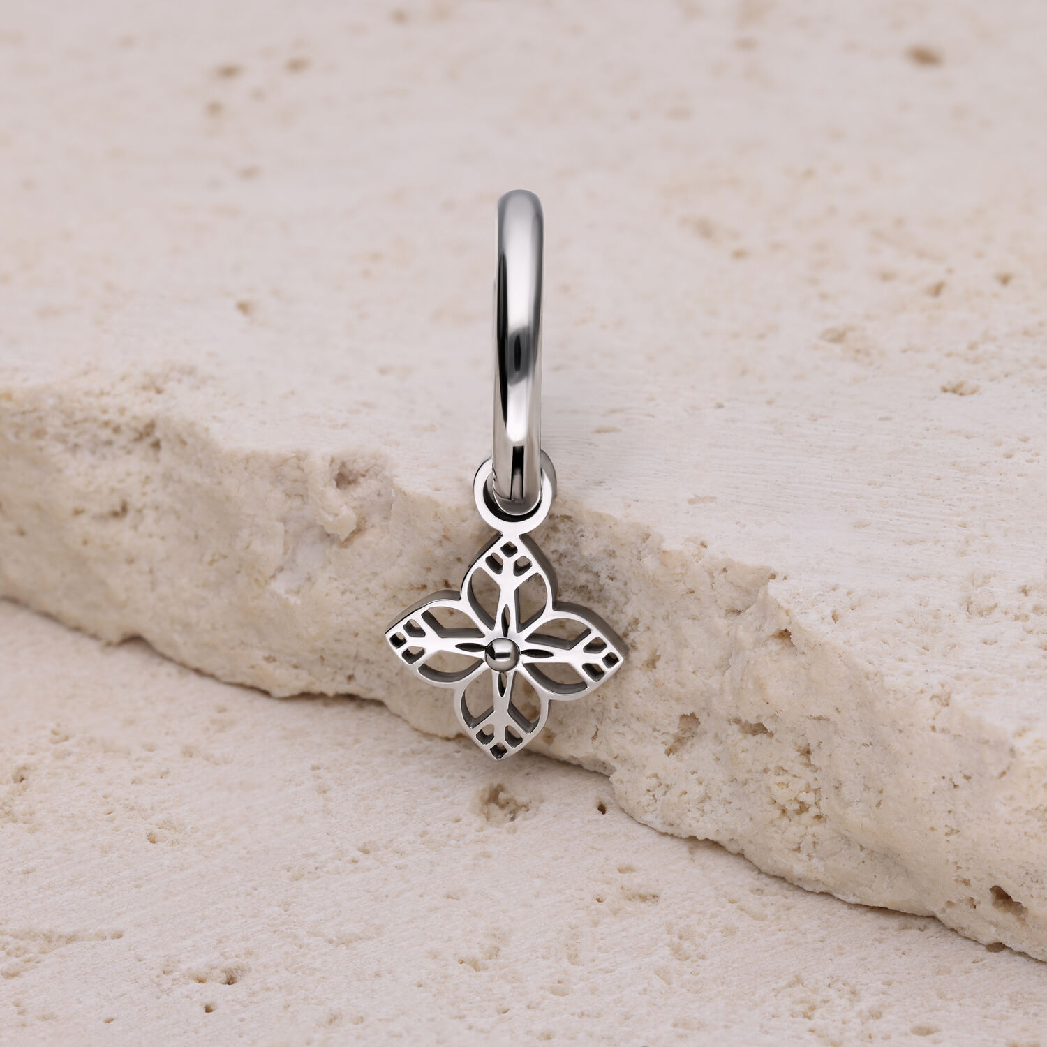 Orecchino argentato con pendente a forma di fiore su pietra chiara