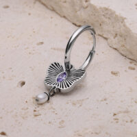 Creola in argento con ornamento floreale e cristallo lavanda su pietra chiara