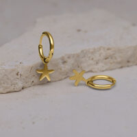 Mini Orecchini a Cerchio Zlata con Stelle Marine Dorate Due orecchini a cerchio dorati con ciondoli a stella marina su una superficie di pietra