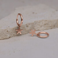 Due orecchini a cerchio in oro rosa con ciondoli a forma di stella marina su pietra chiara