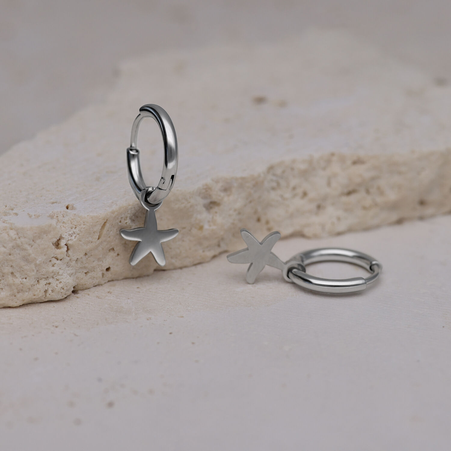 Due orecchini a cerchio in argento con ciondolo a stella marina su pietra chiara